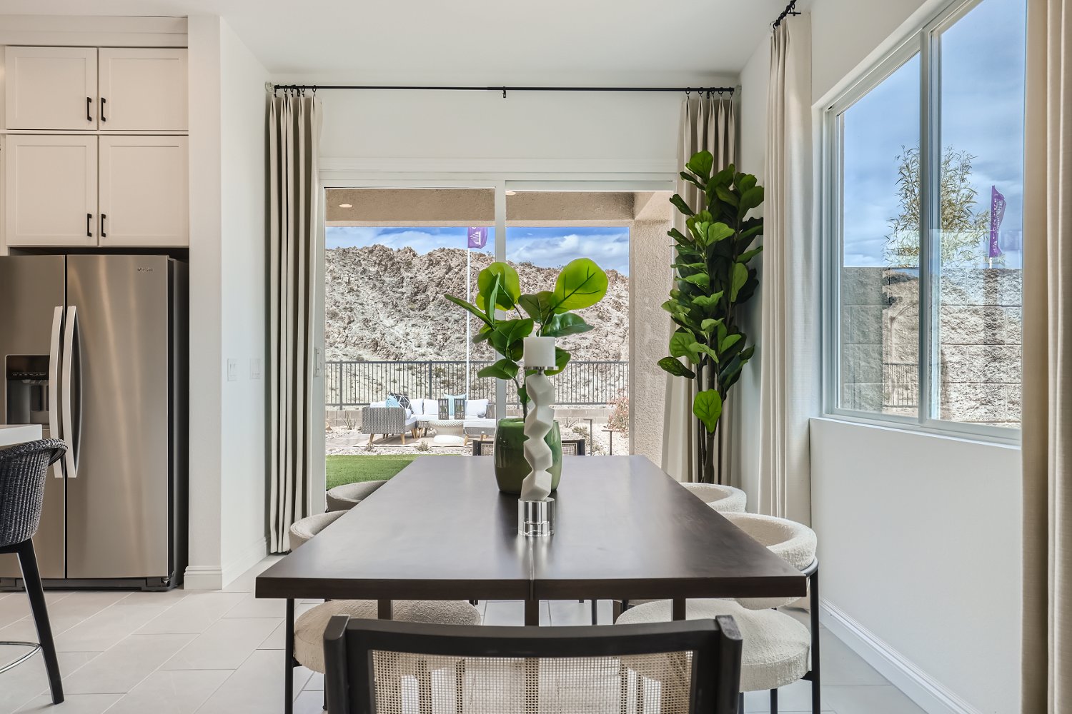 A dining table with a vase of flowers on it.