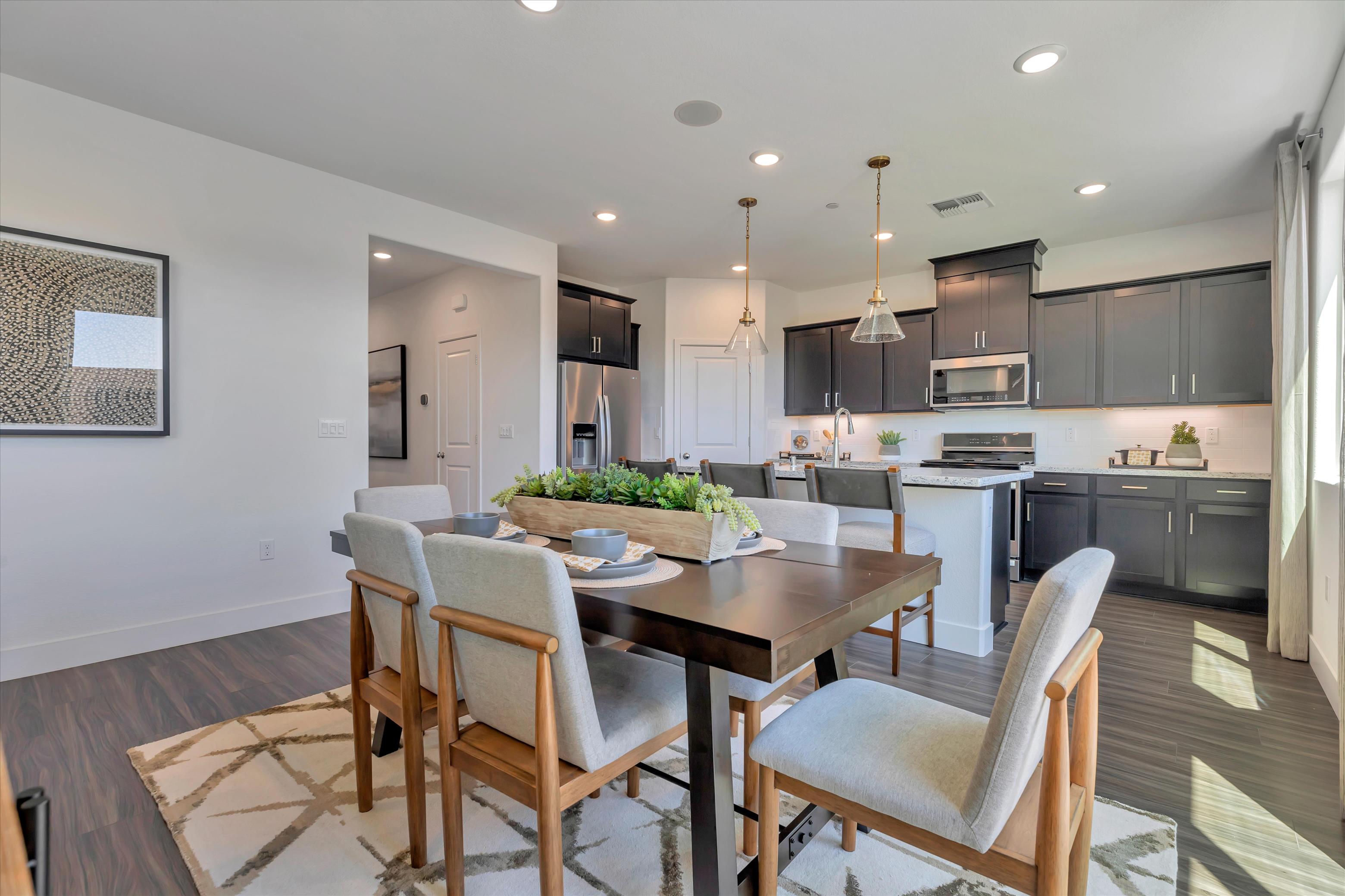 A kitchen with a dining table and chairs.