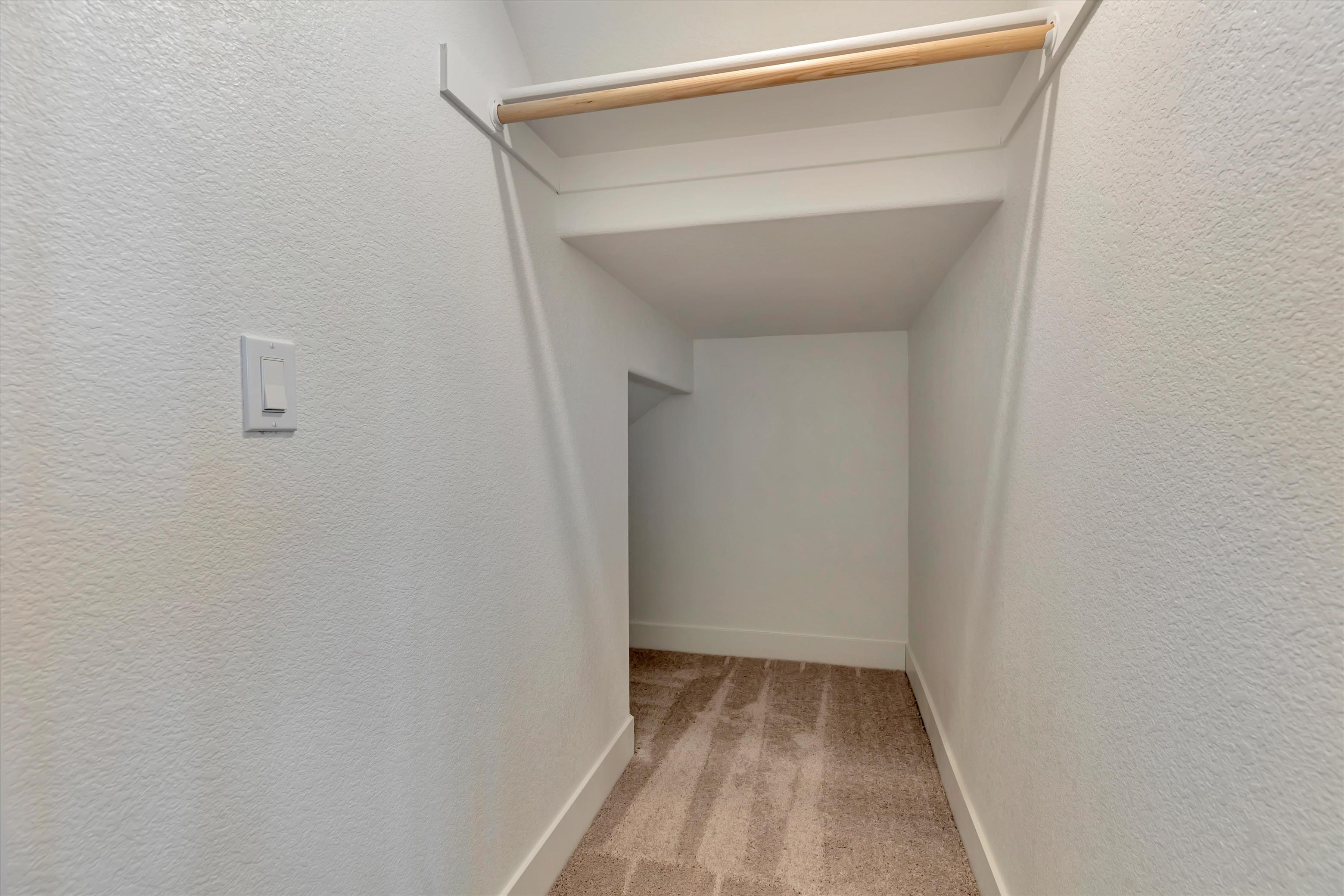 A white hallway with a light on the ceiling.