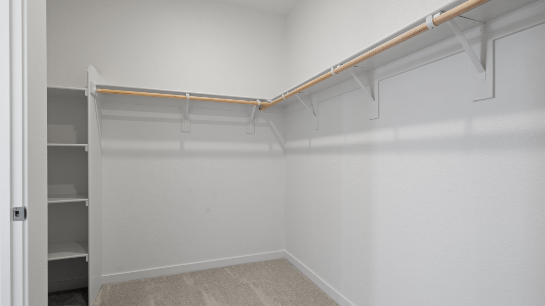 A white wall with a metal bar.