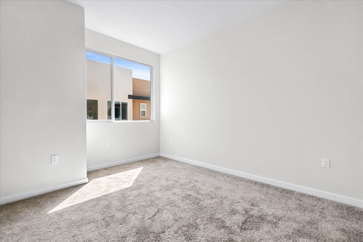 A room with a window and carpet.