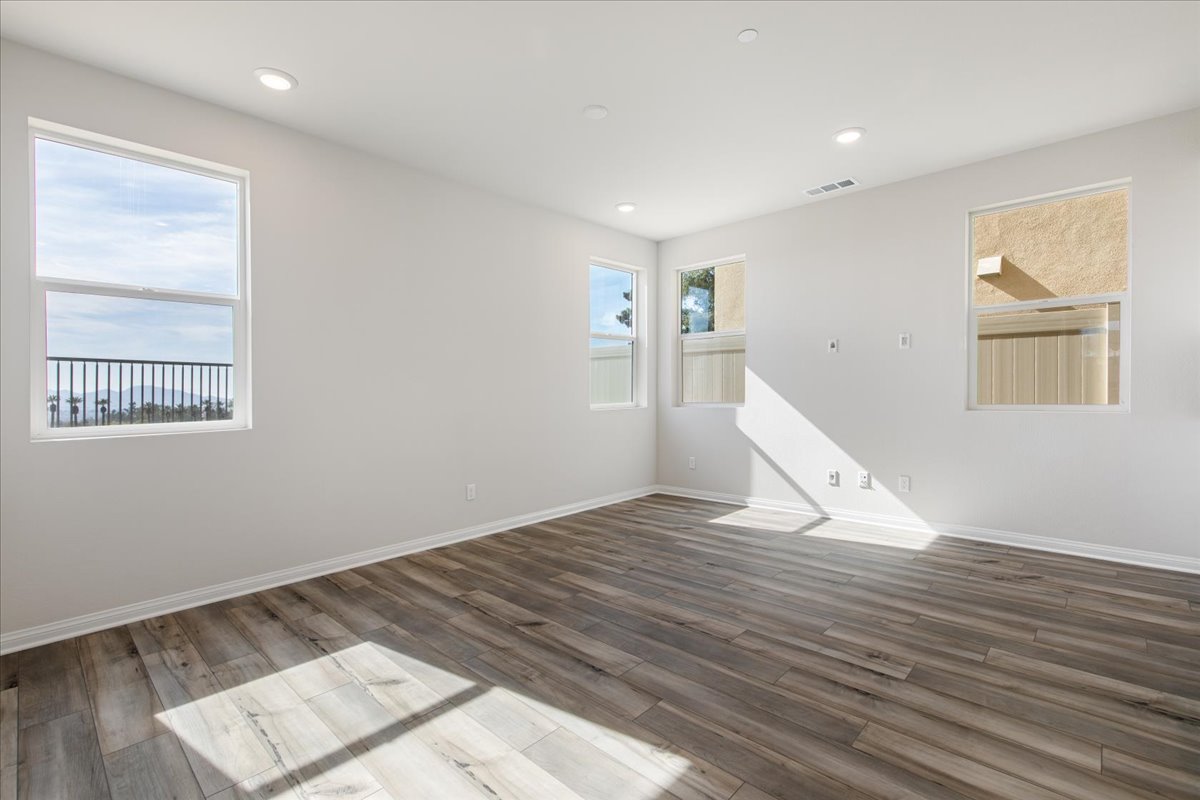A room with a wood floor and windows.