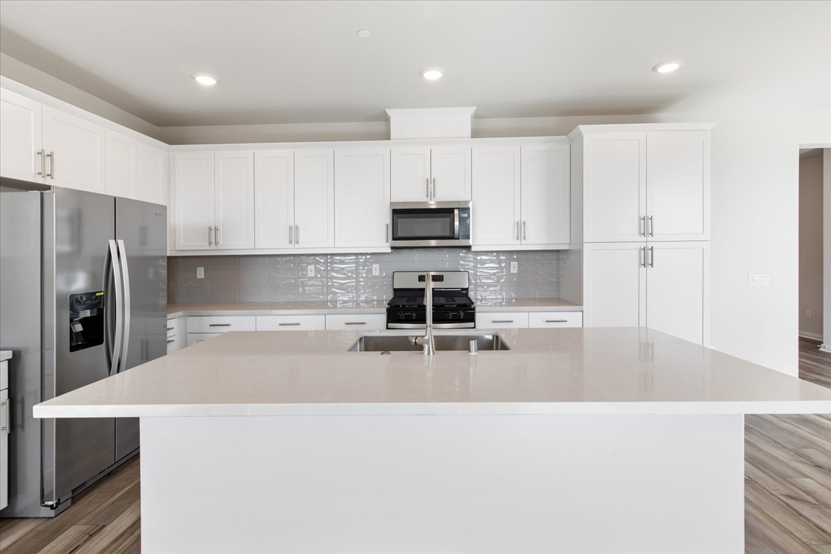 A kitchen with white cabinets.