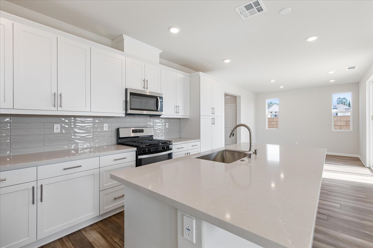 A kitchen with white cabinets.