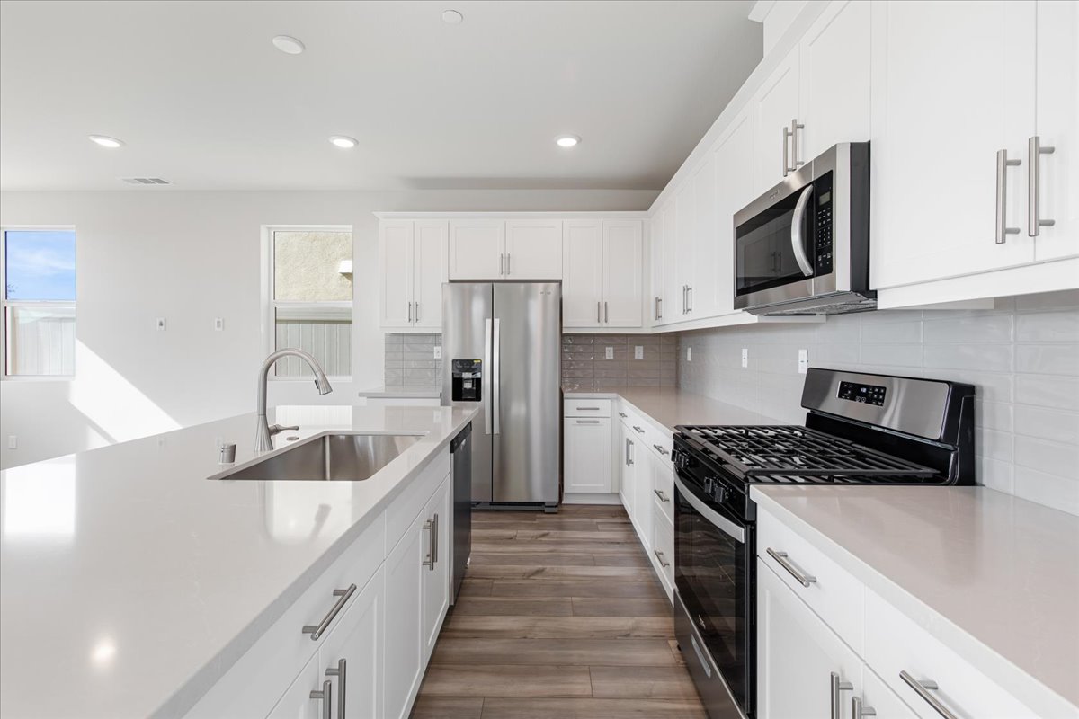 A kitchen with white cabinets.
