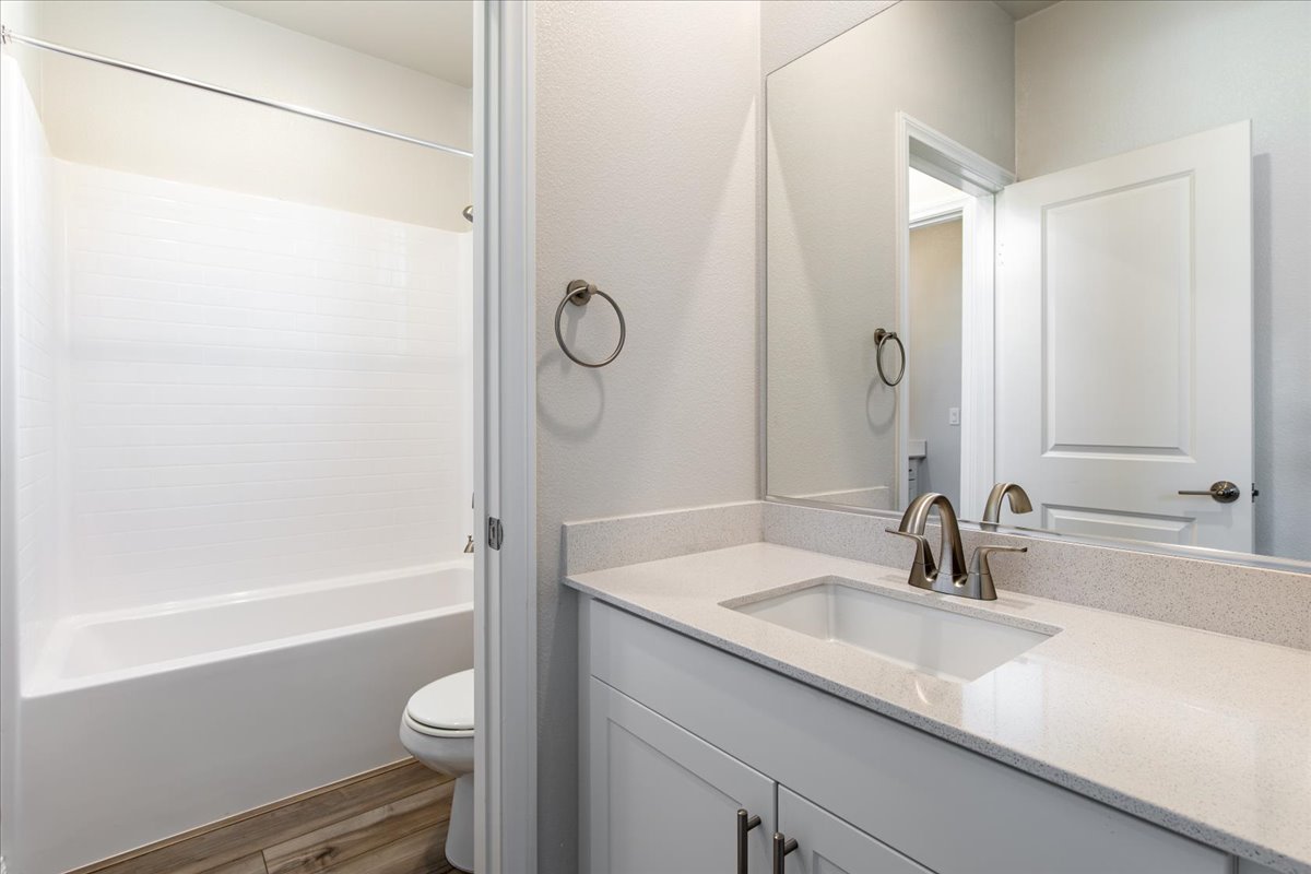 A bathroom with a sink toilet and shower.