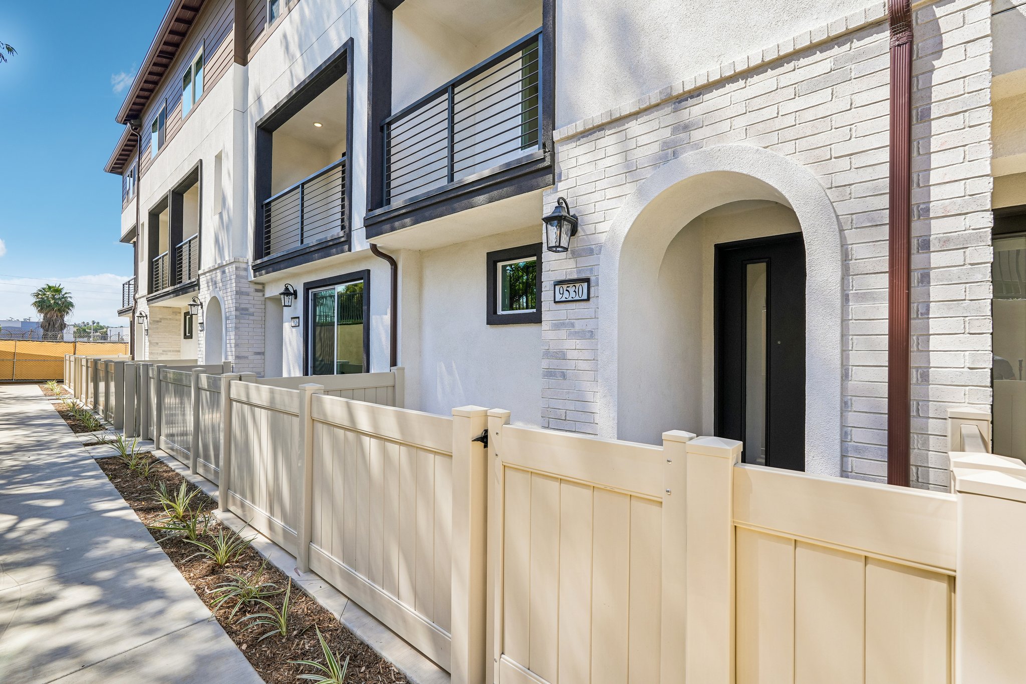 A white building with a white fence.