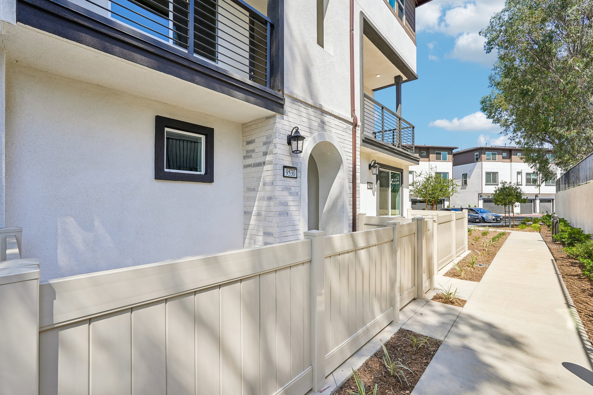 A white building with a white fence.