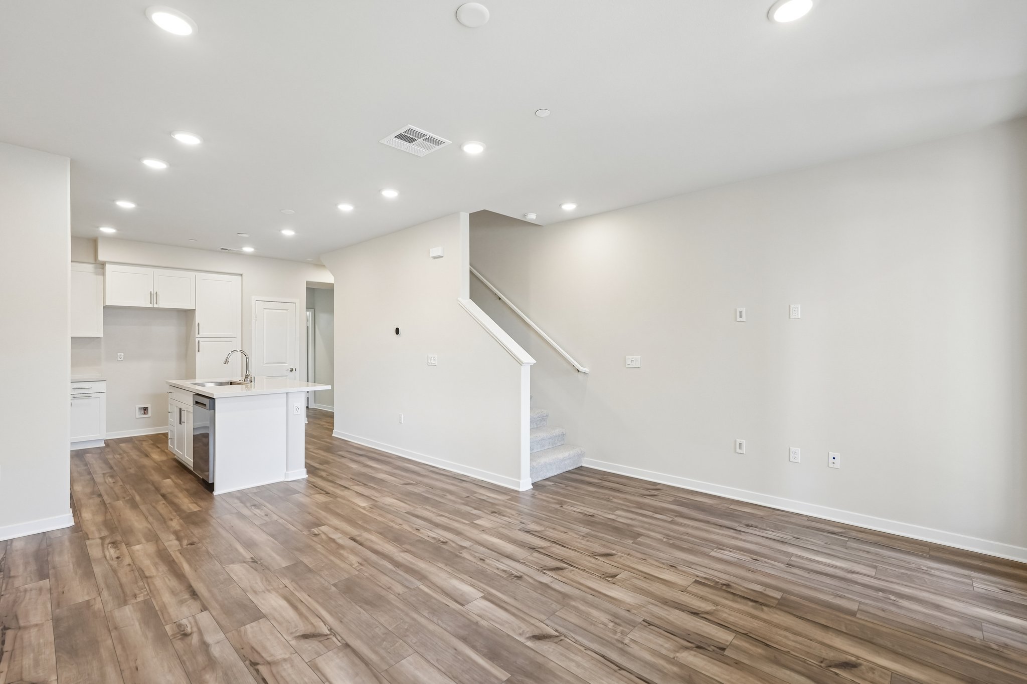 A room with white walls and wood floors.