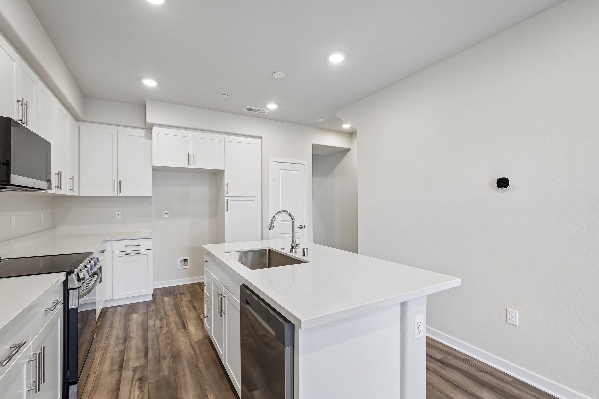 A kitchen with white cabinets.