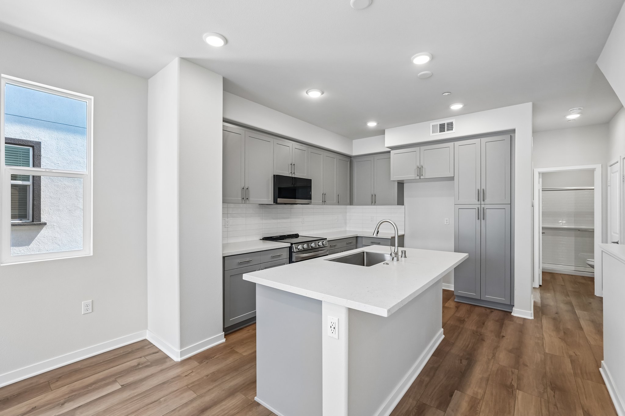 A kitchen with white cabinets.