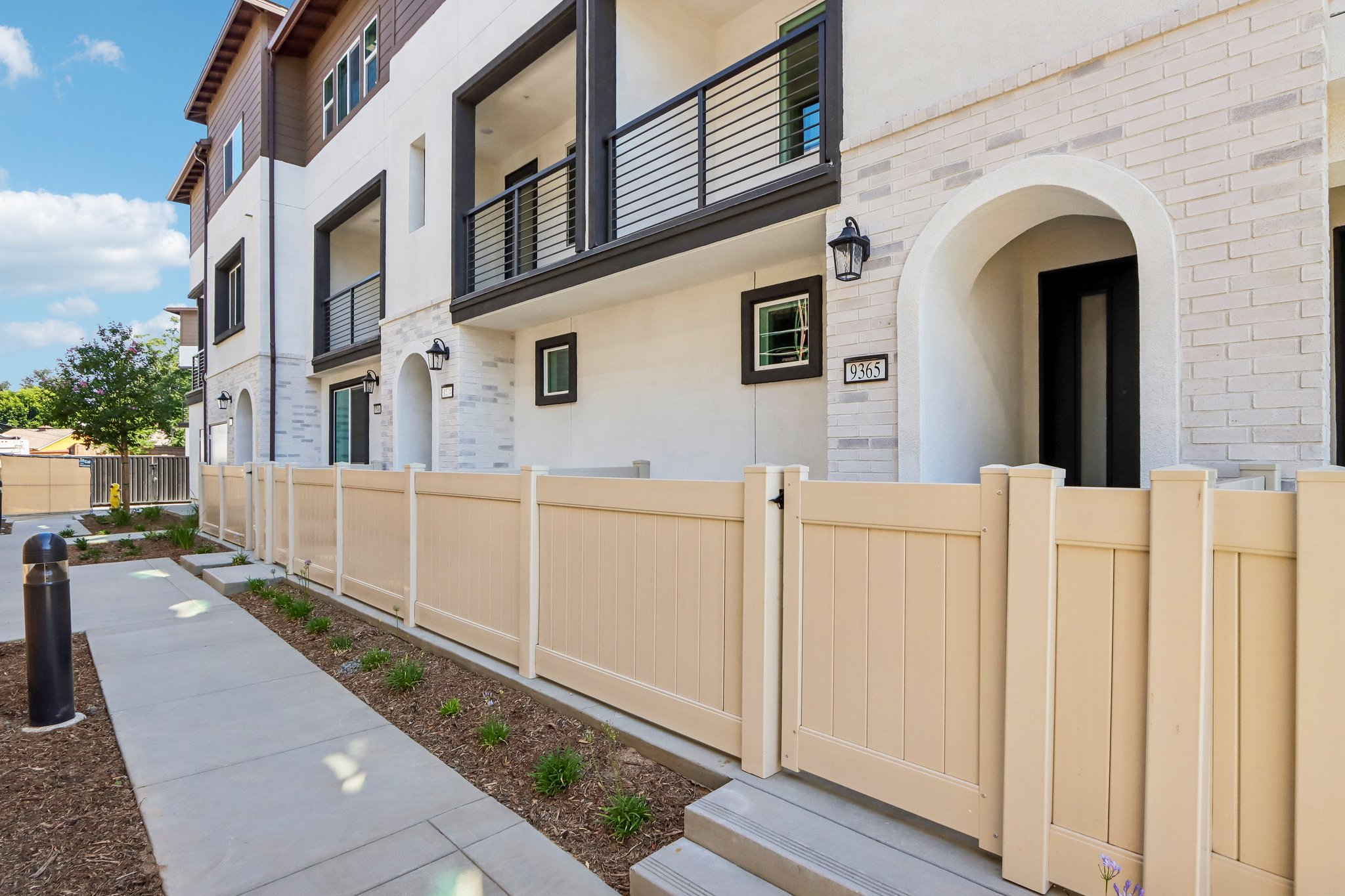 A white building with a white fence.