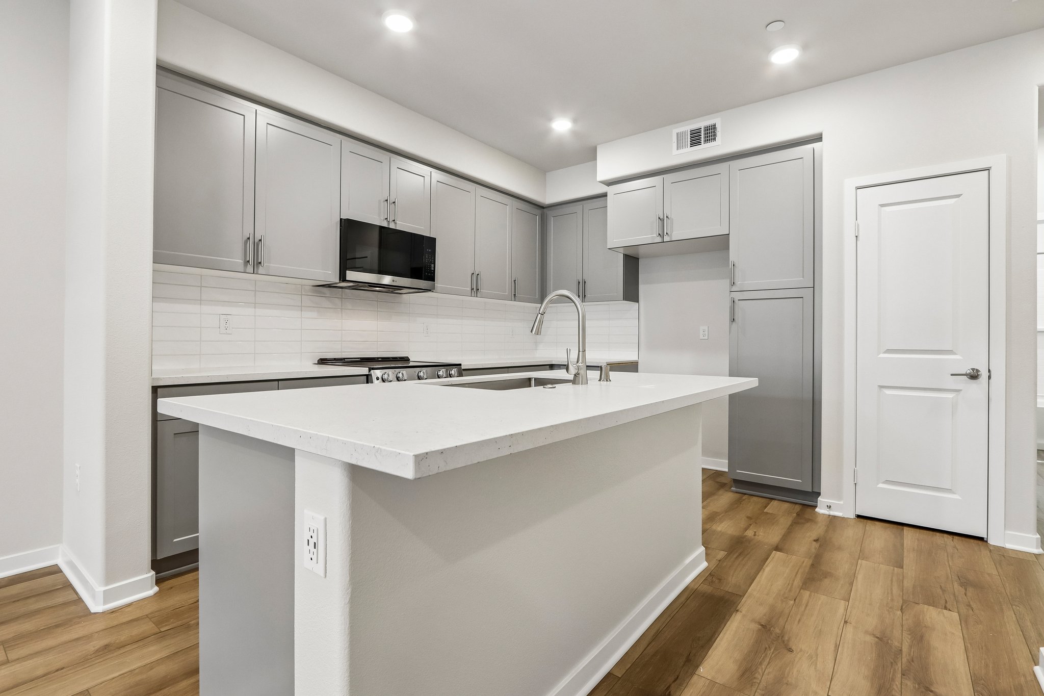A kitchen with white cabinets.