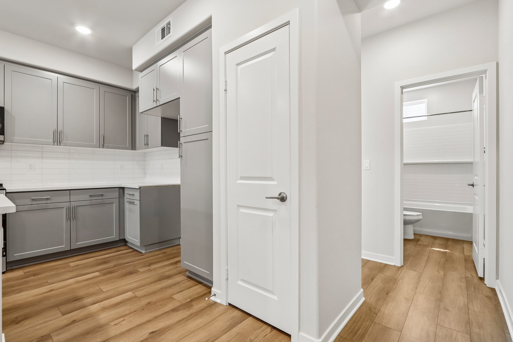 A kitchen with white cabinets.
