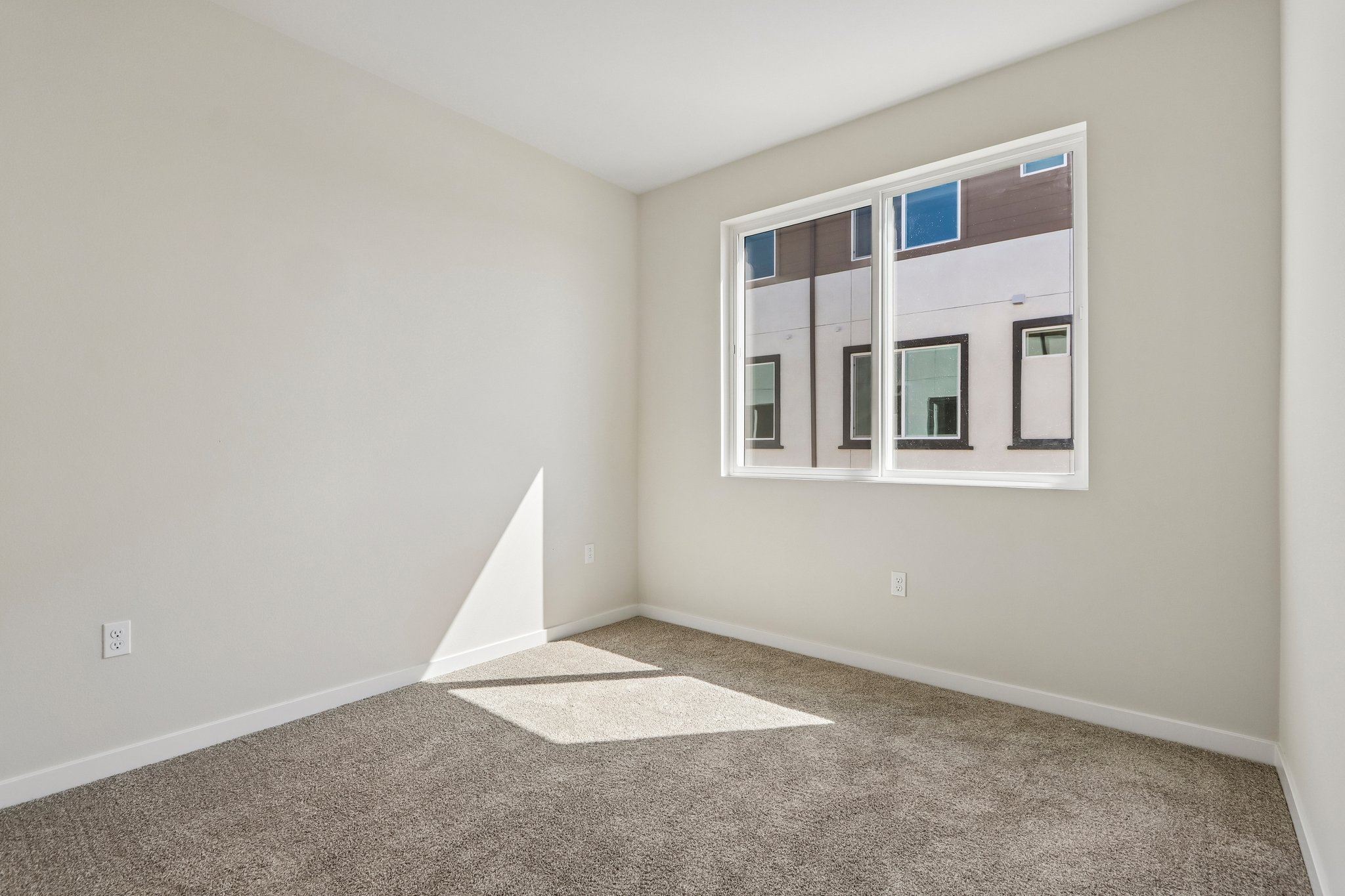 A room with a window and a rug.