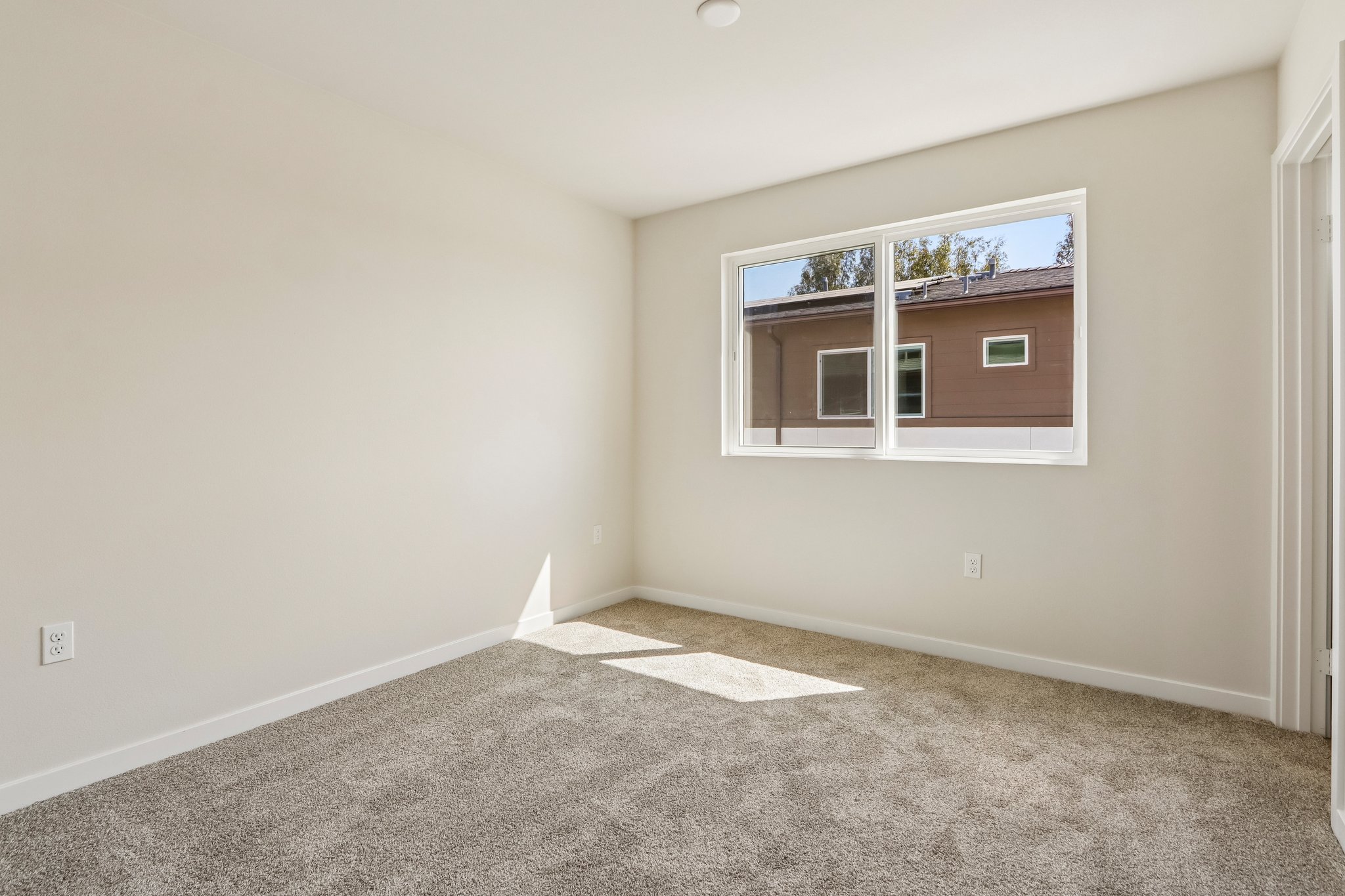 A room with a window and carpet.