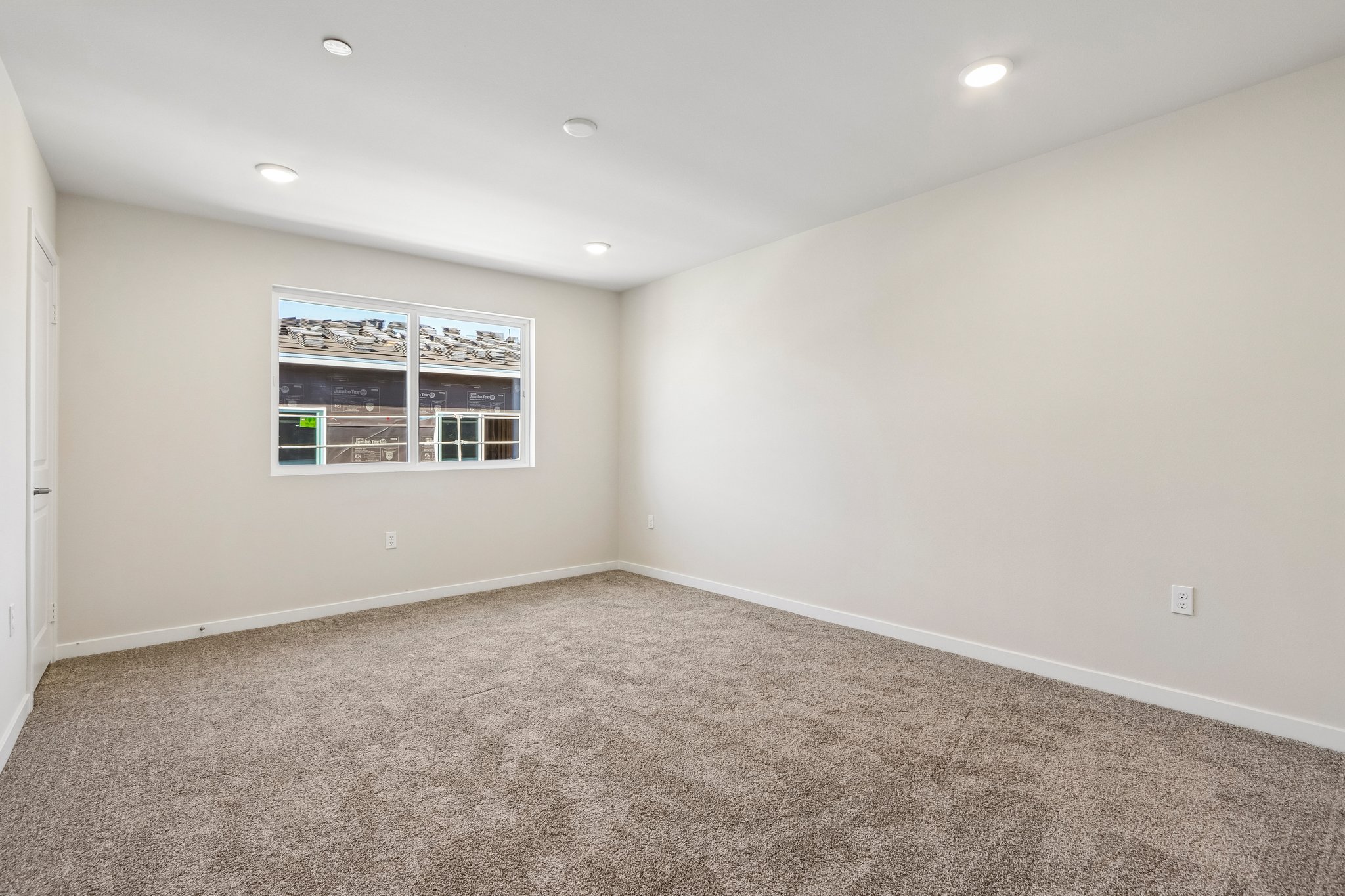 A room with a carpet and a window.