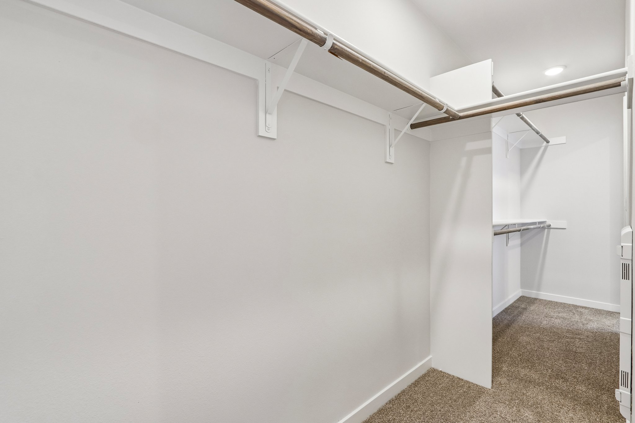 A white wall with a metal bar.