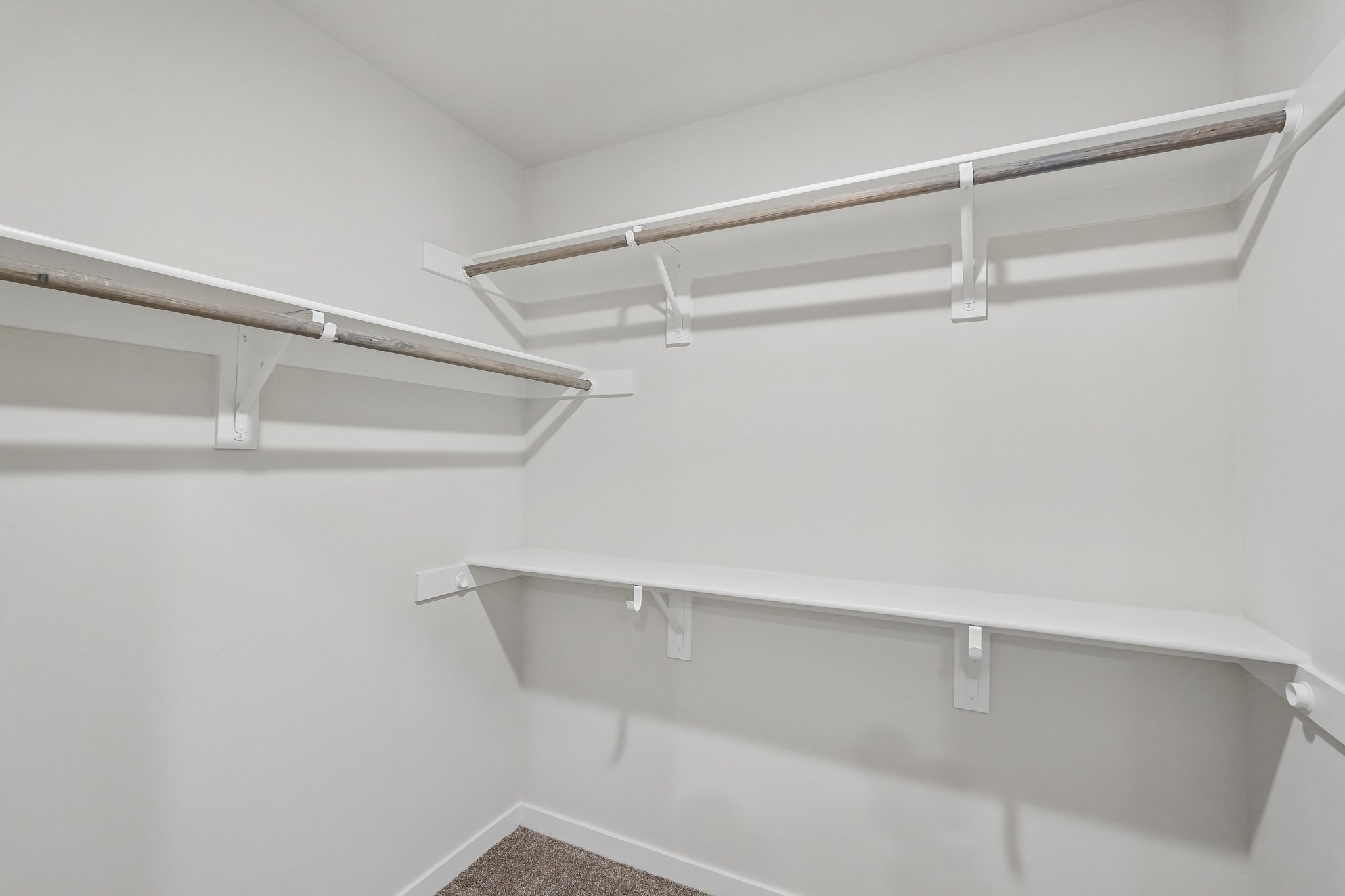 A white wall with a metal bar.