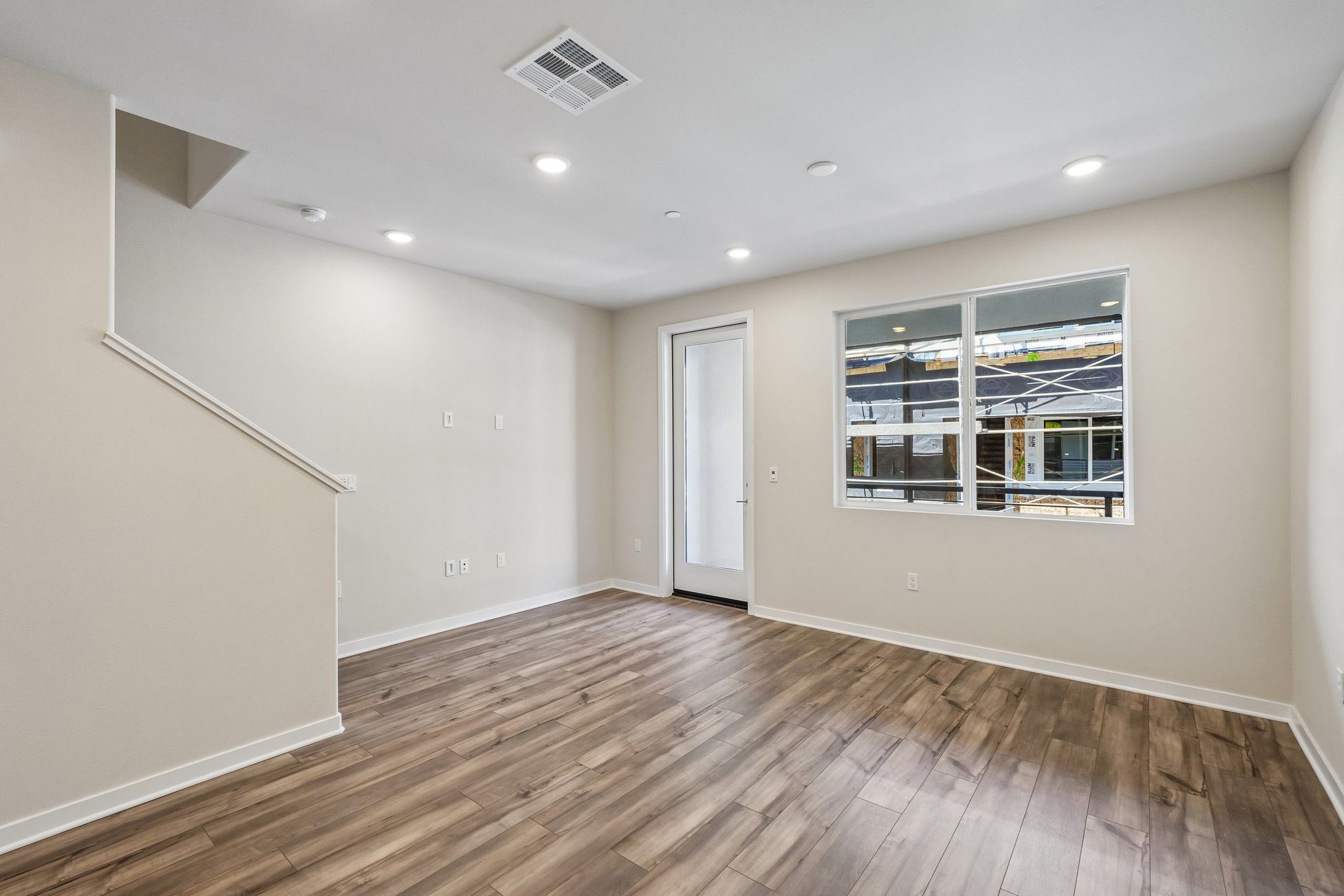 A room with a wood floor and a window.