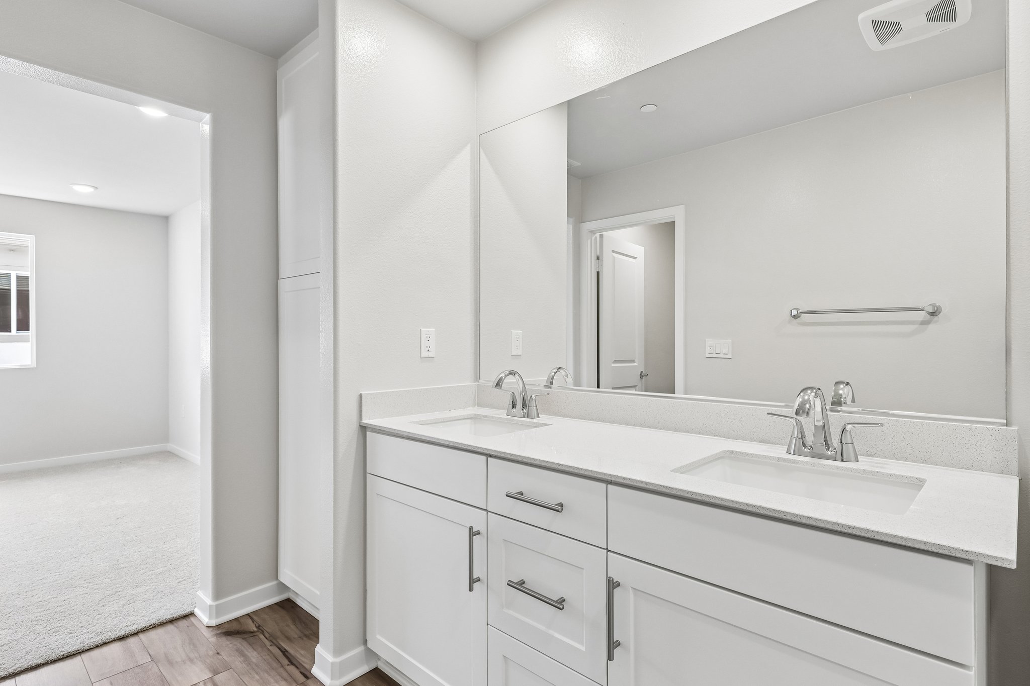 A bathroom with white cabinets.