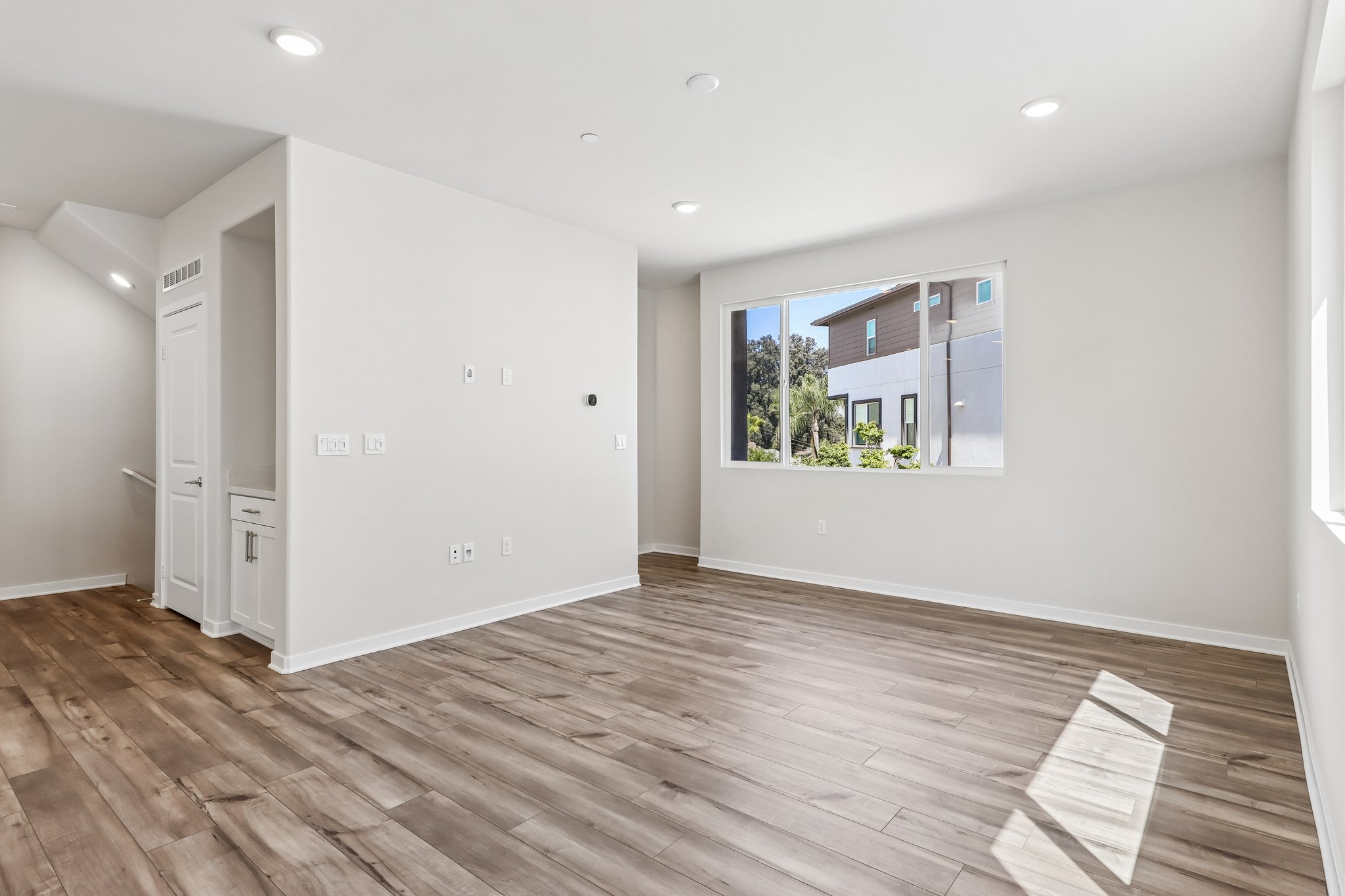A room with a wood floor and a window.