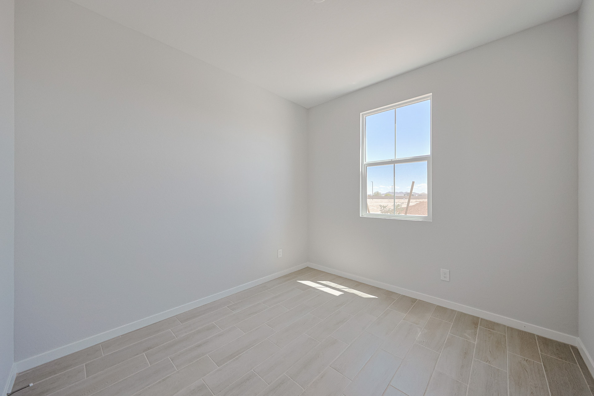 A room with a window and tile floor.