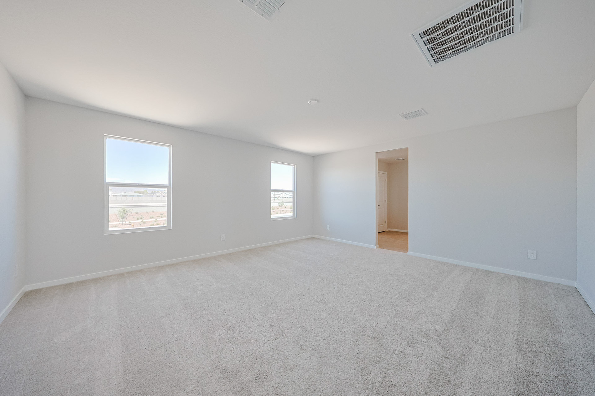 A room with a carpet and windows.