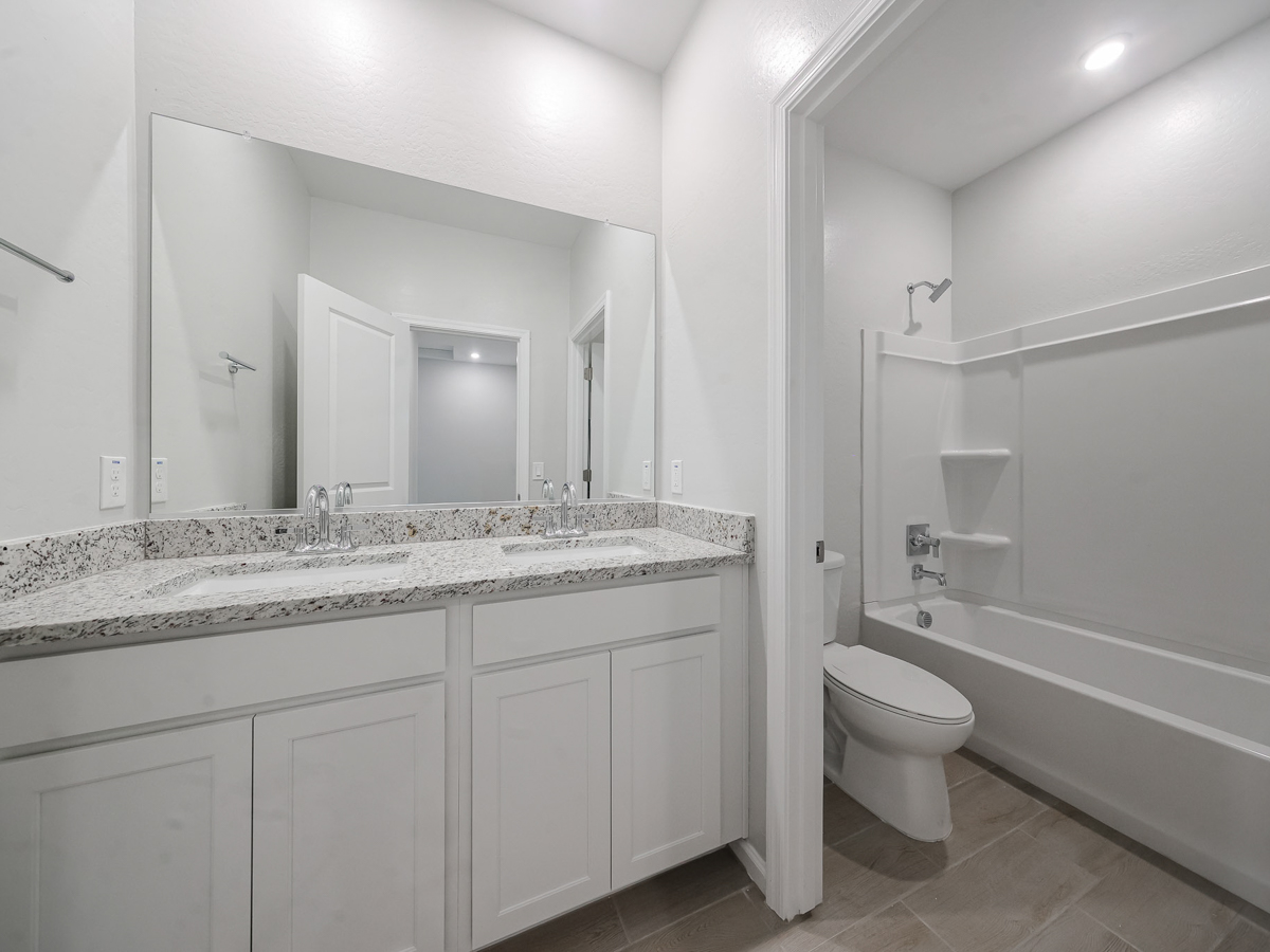 A bathroom with a tub sink and toilet.