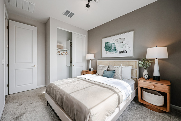 A bedroom with a bed and lamps.