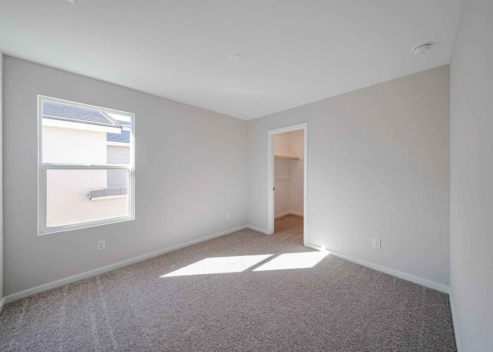 A room with a carpet and a window.