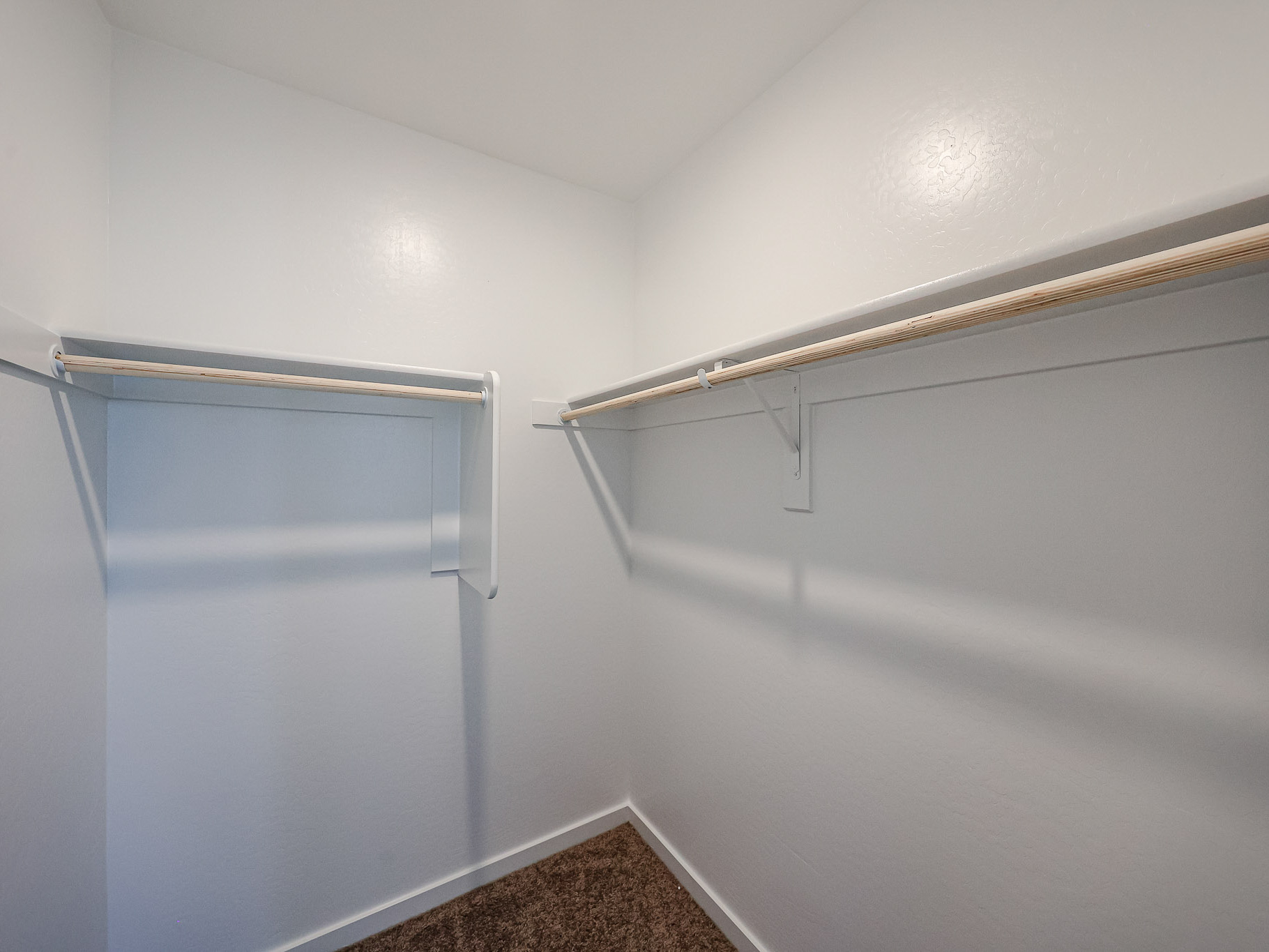 A white wall with a metal bar.