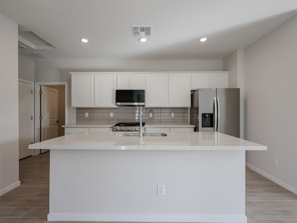 A kitchen with white cabinets.