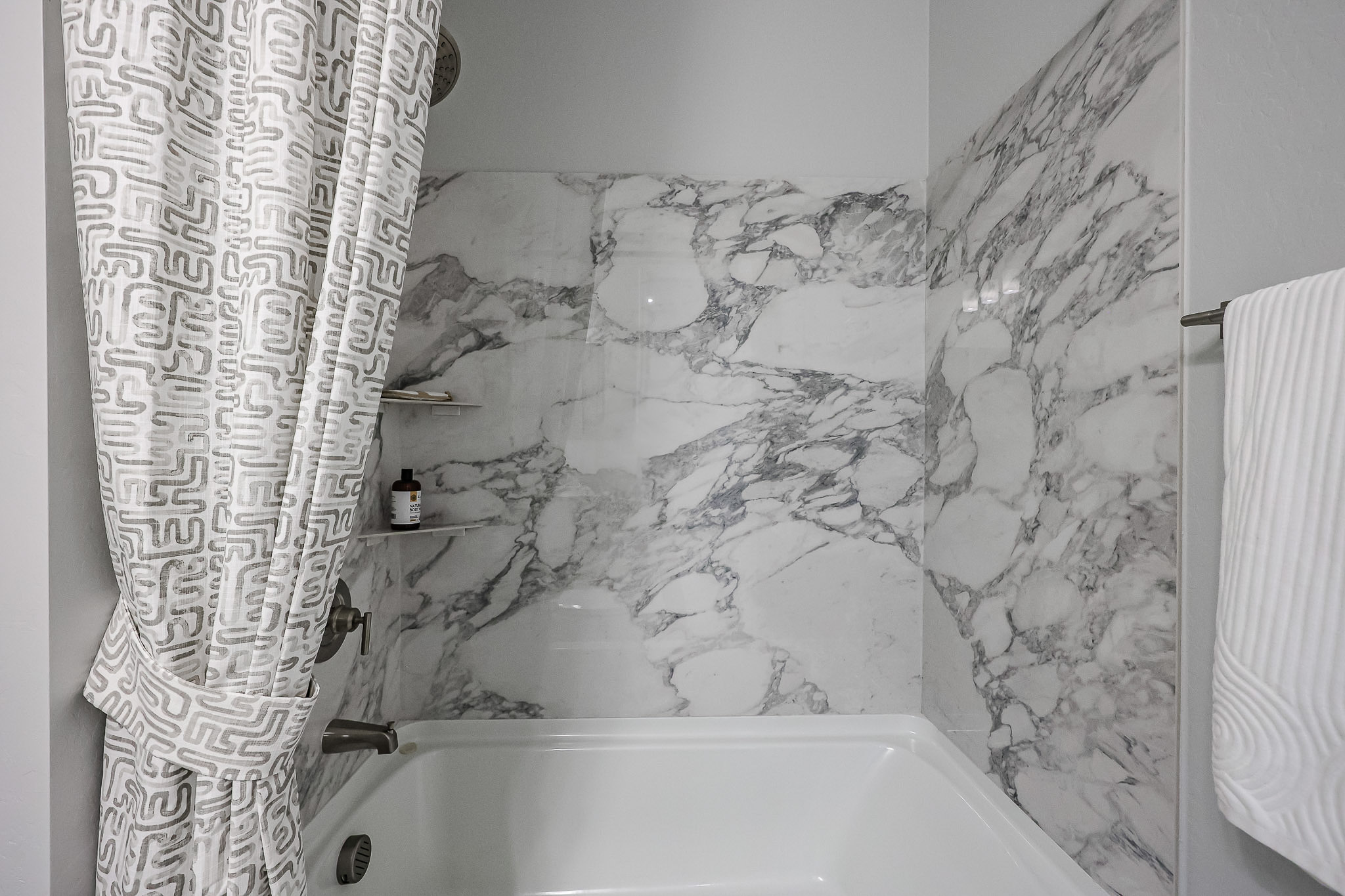 A bathroom with a white shower curtain.