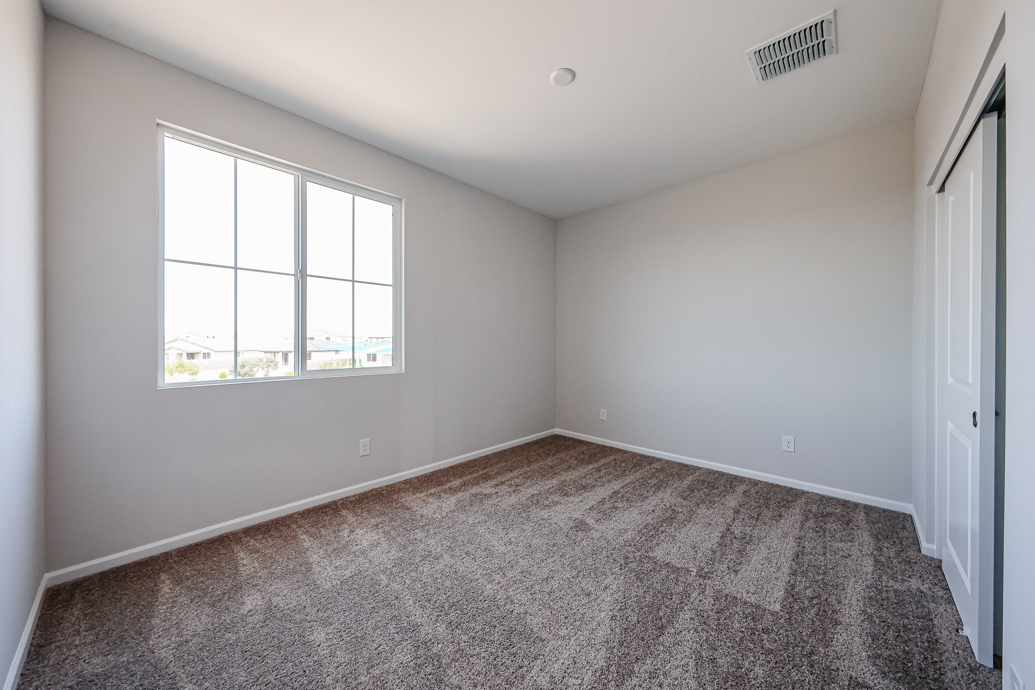 A room with a window and carpet.