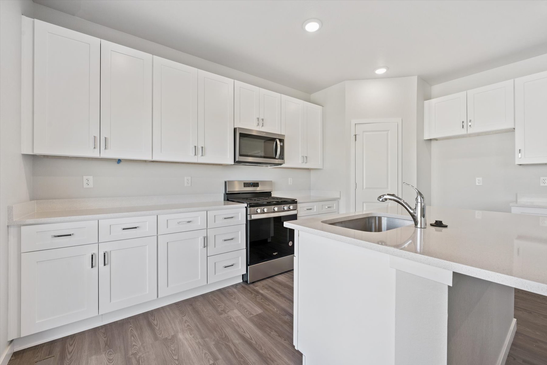 A kitchen with white cabinets.