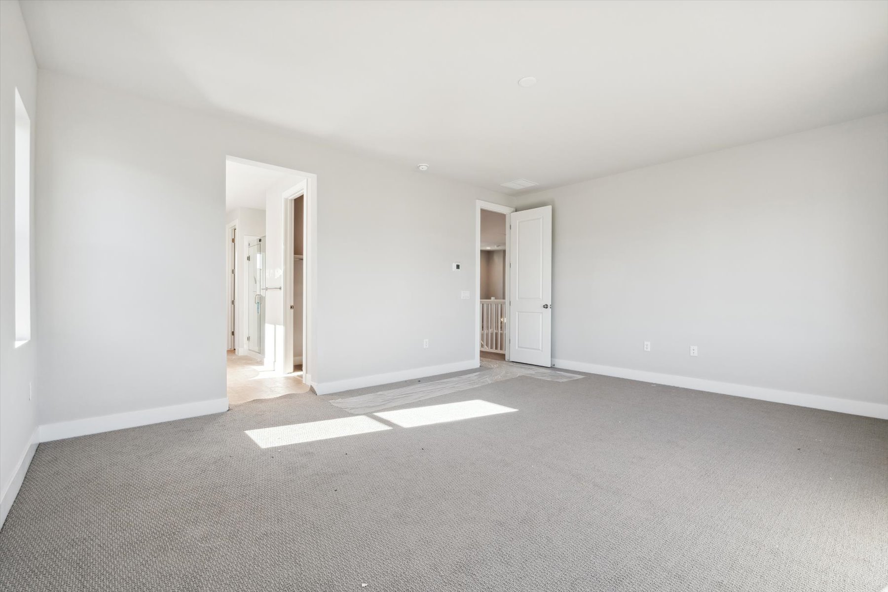 A long hallway with white doors.