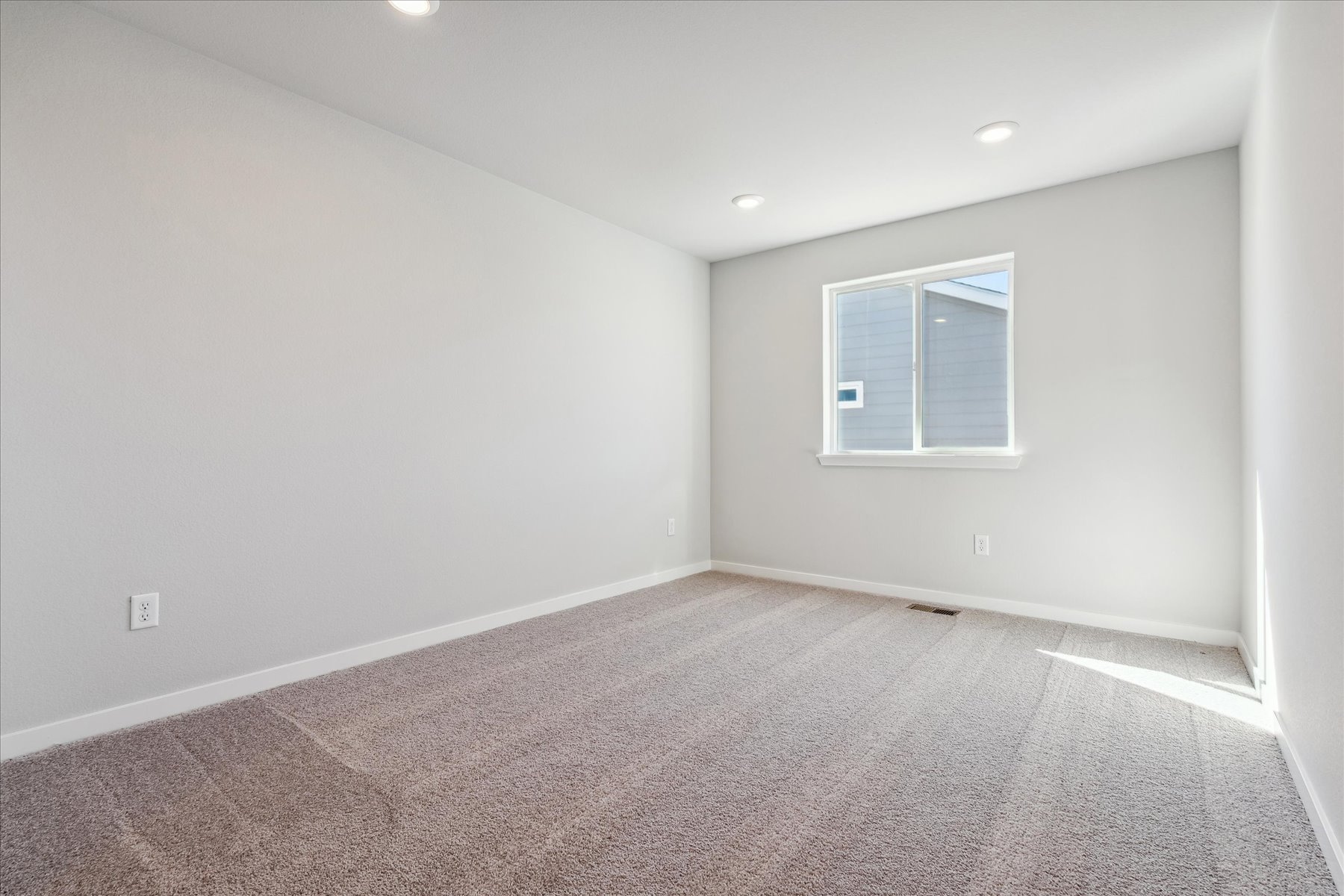 A room with a carpet and a window.