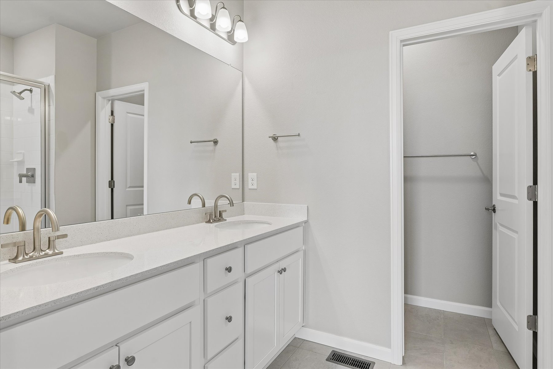 A bathroom with a sink and a shower unit.