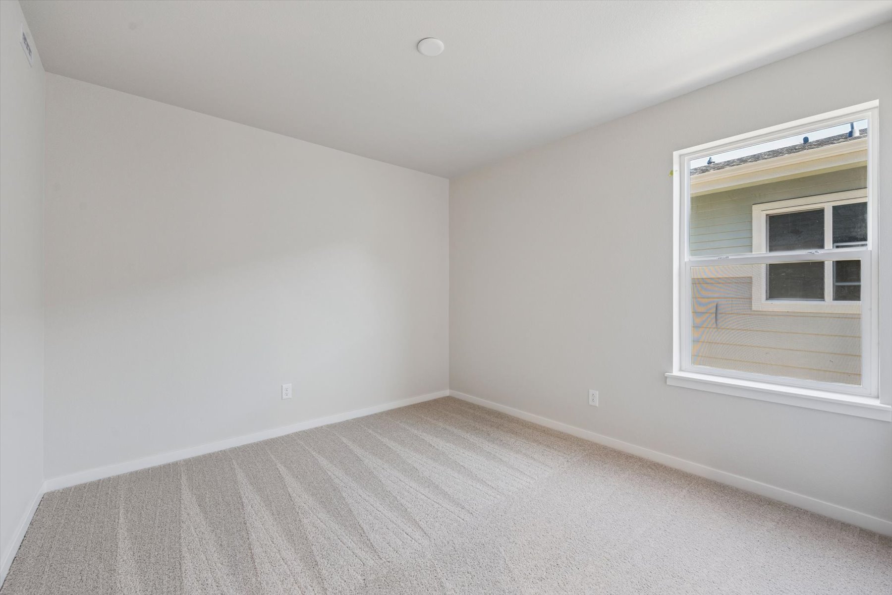 A room with a window and a carpet.