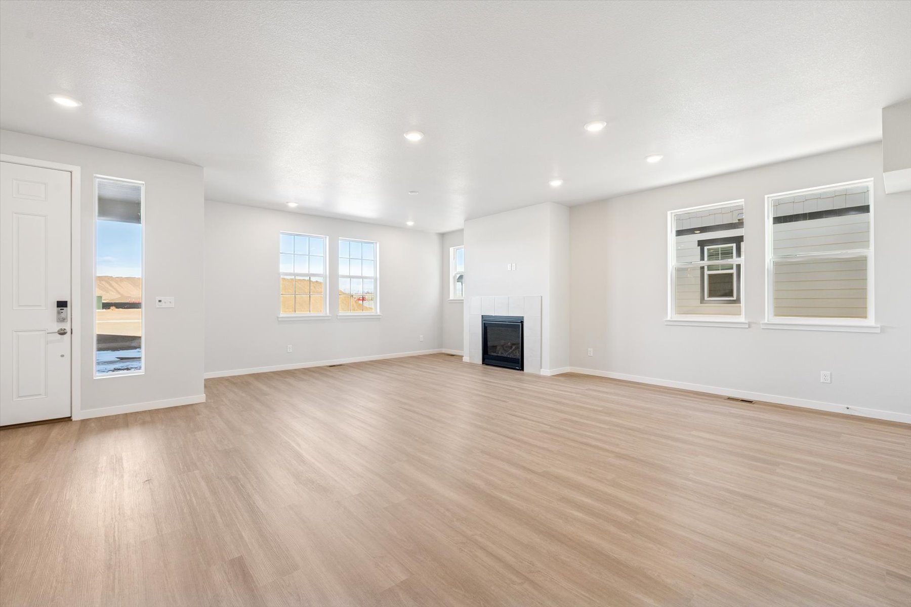 A large empty room with a wood floor and white walls.