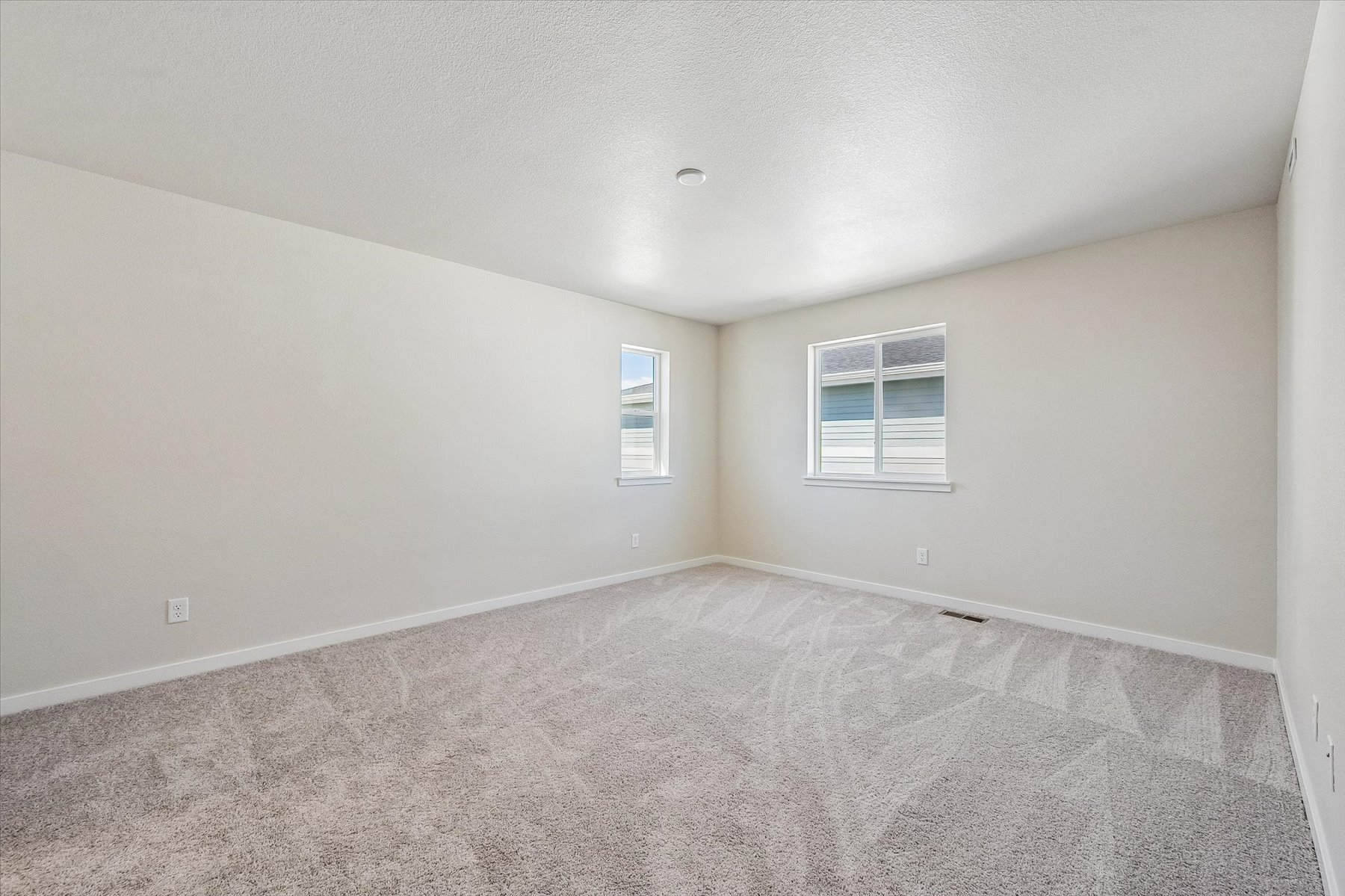 A room with a carpet and a window.