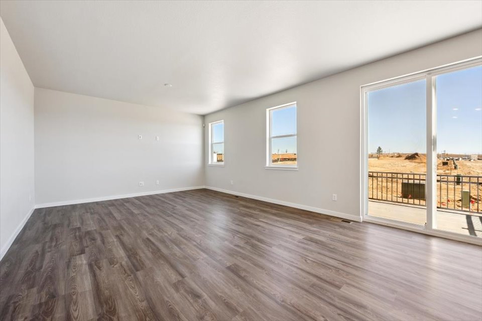 A room with windows and a wood floor.