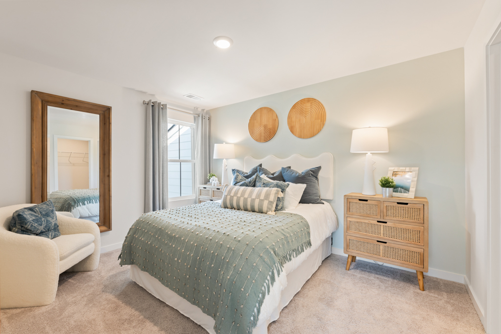 A bedroom with a bed and a mirror.