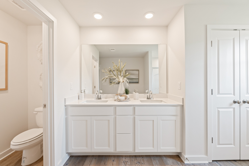 A bathroom with white cabinets.