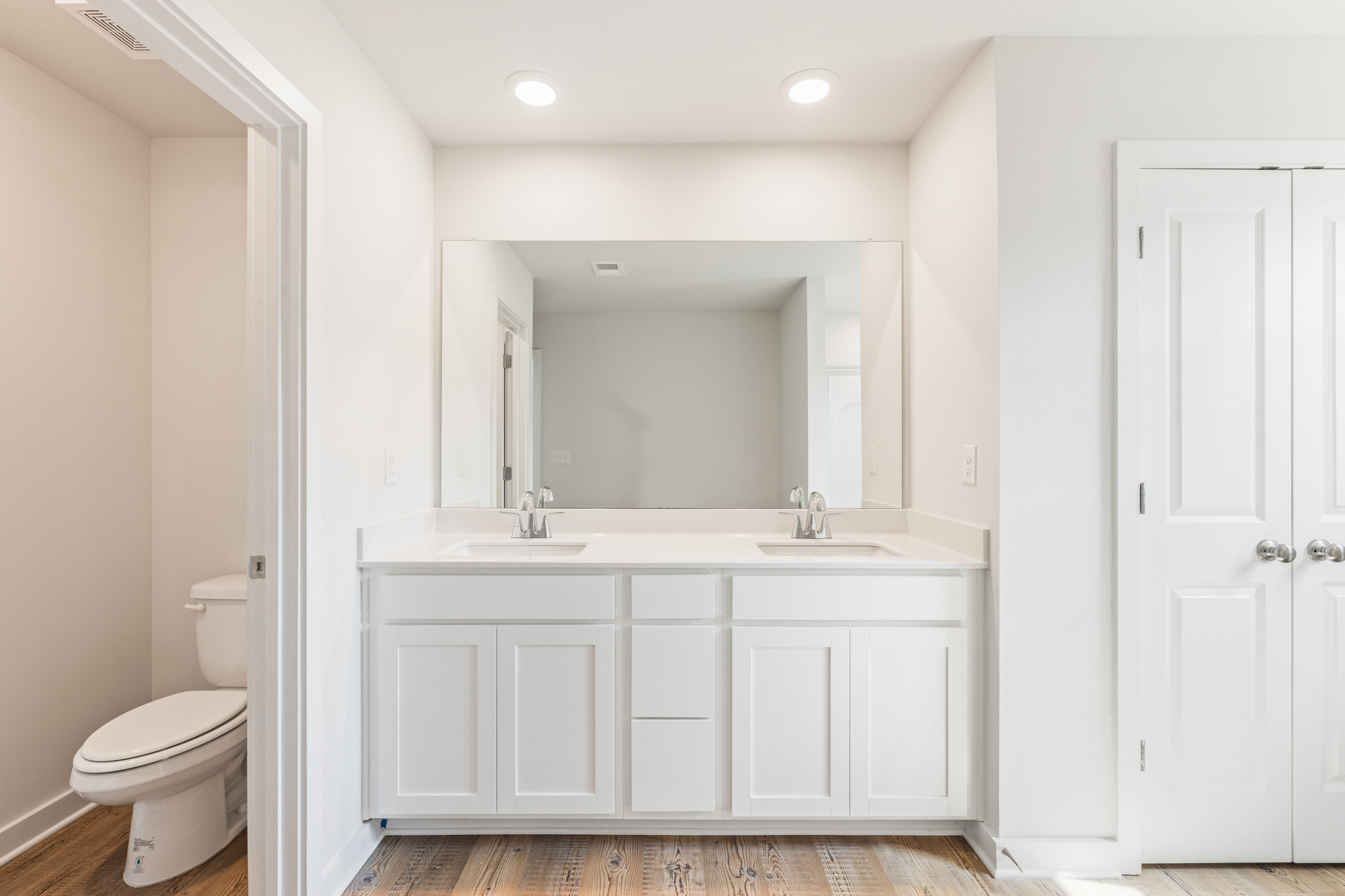 A bathroom with white cabinets.