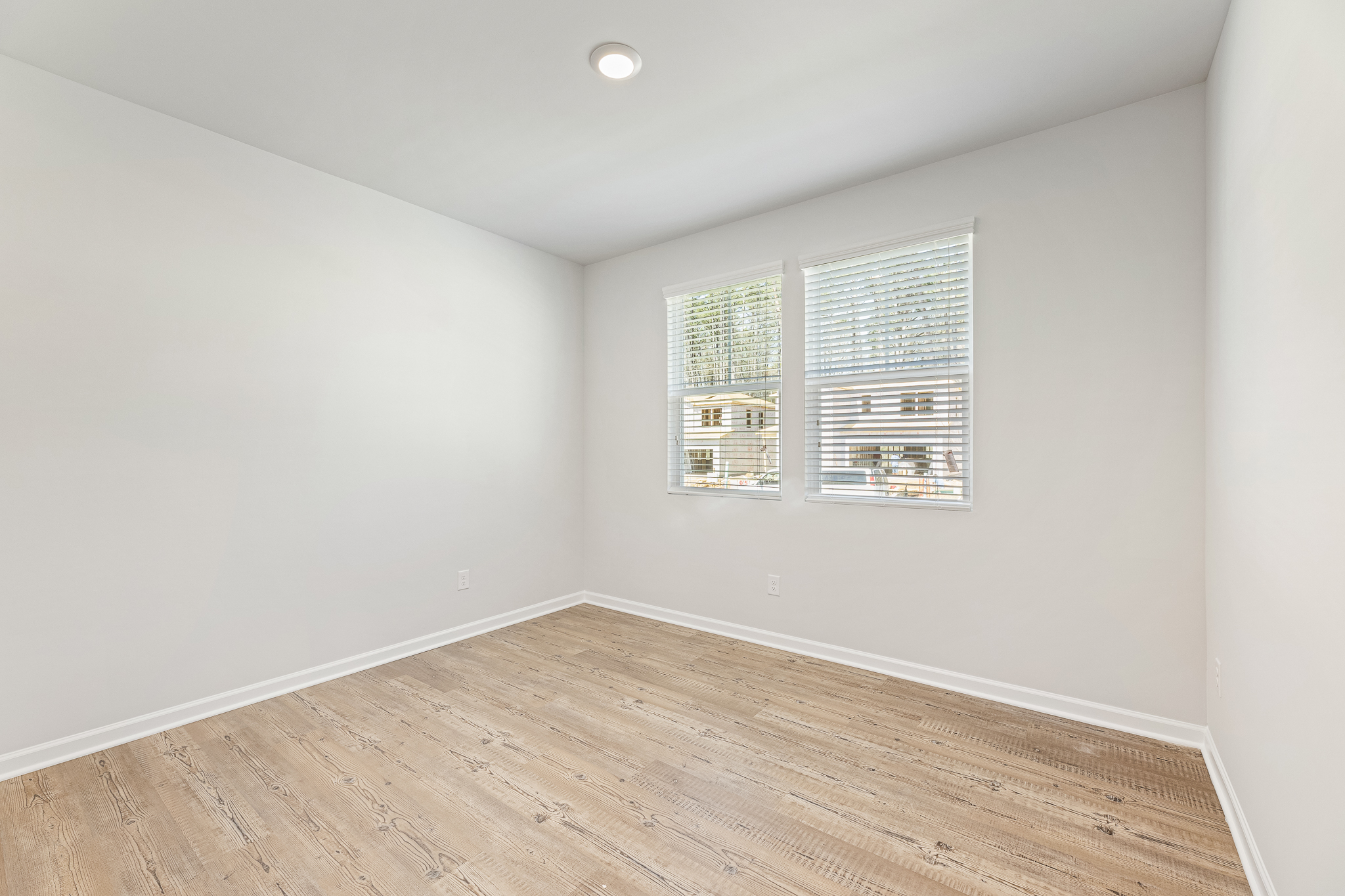 A room with a wood floor and a window.