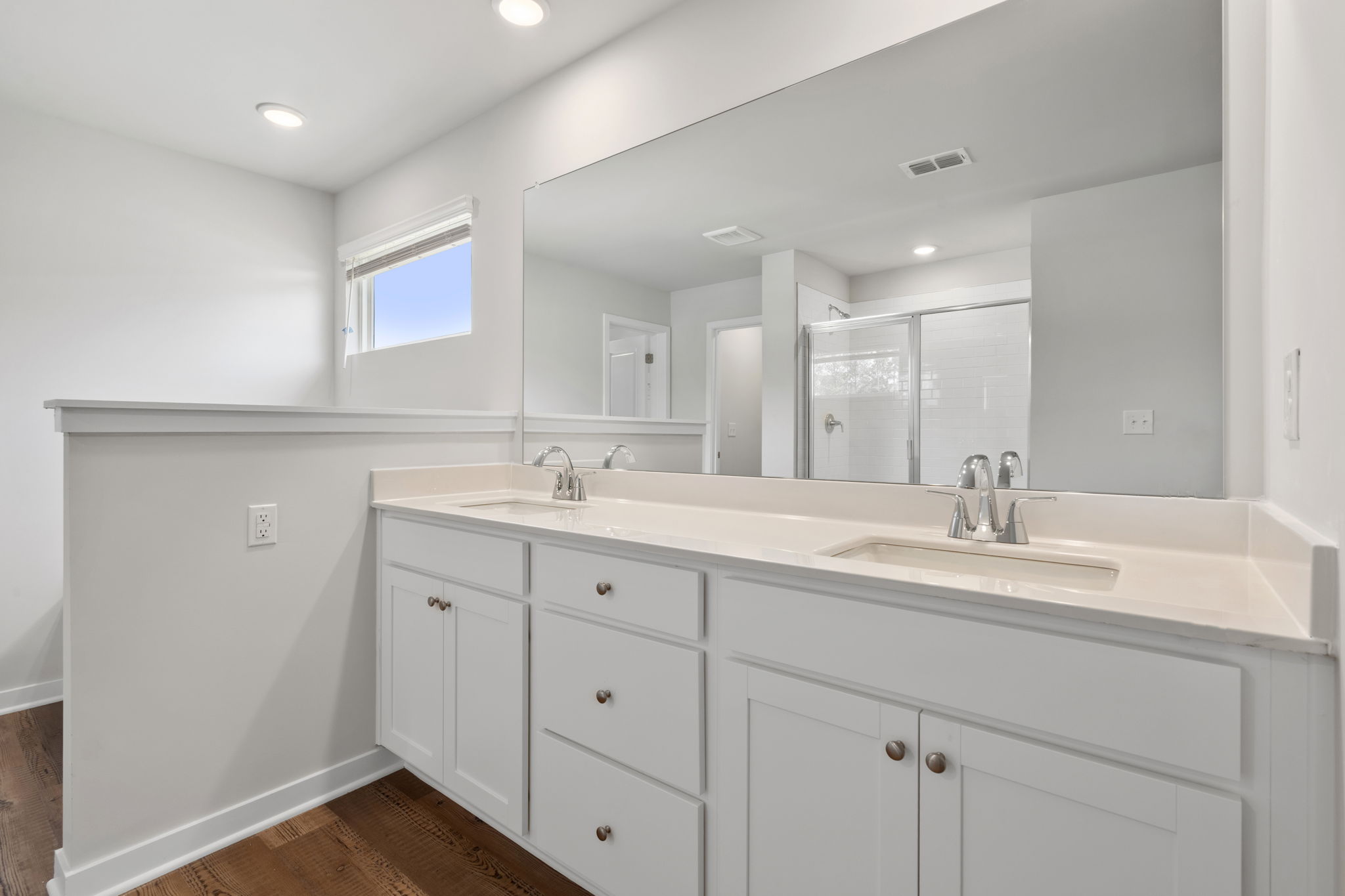 A bathroom with white cabinets.