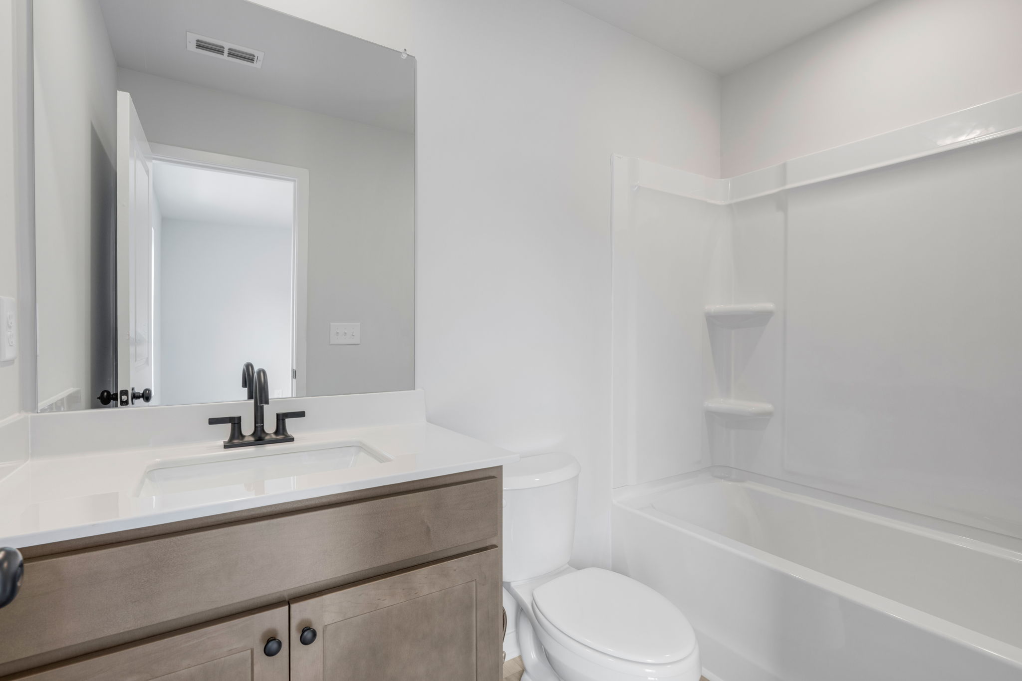 A bathroom with a tub sink and toilet.