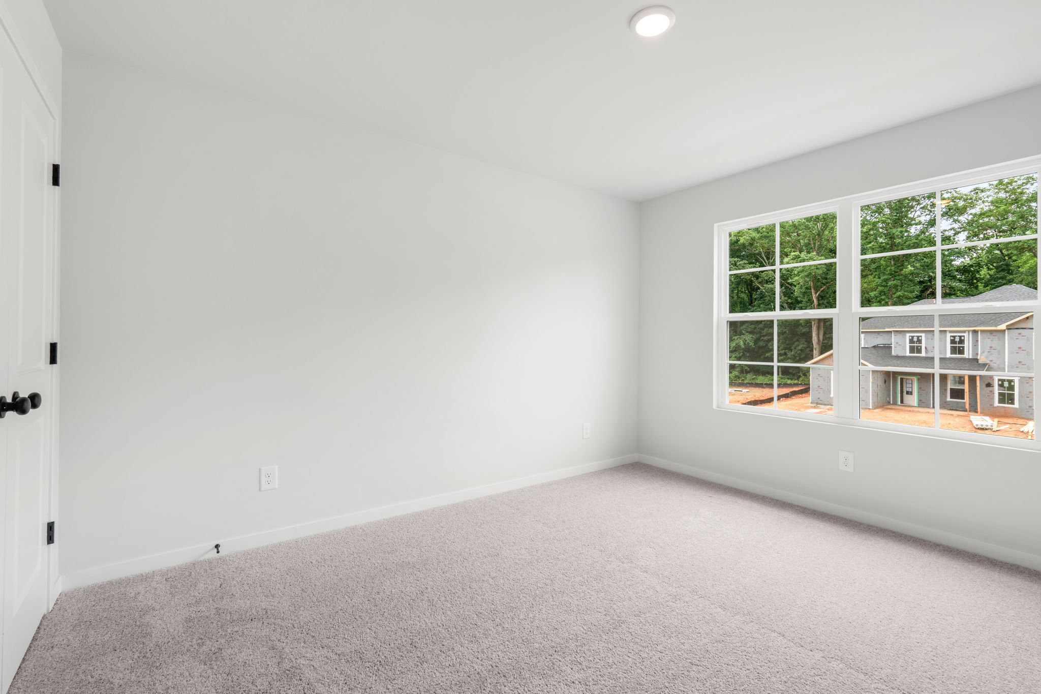A room with a window and a carpet.